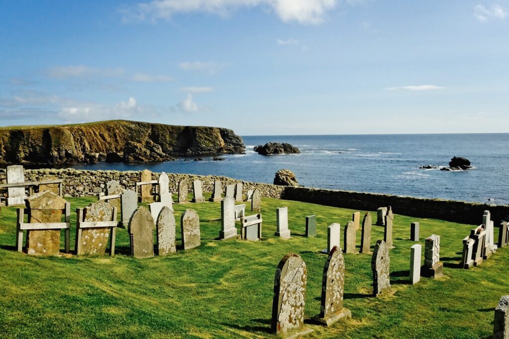 Atmospheric documentary photography of a stone cemetery overlooking the North Sea cliffs