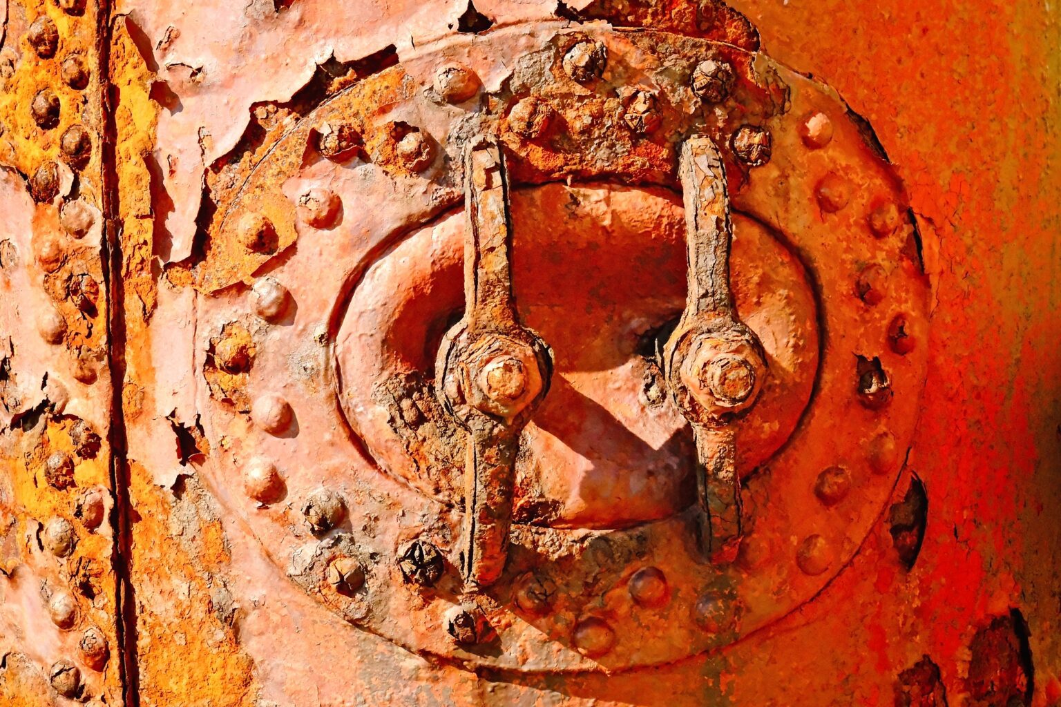 Close-up abstract editorial of deep orange rust and weathered metal textures on maritime equipment