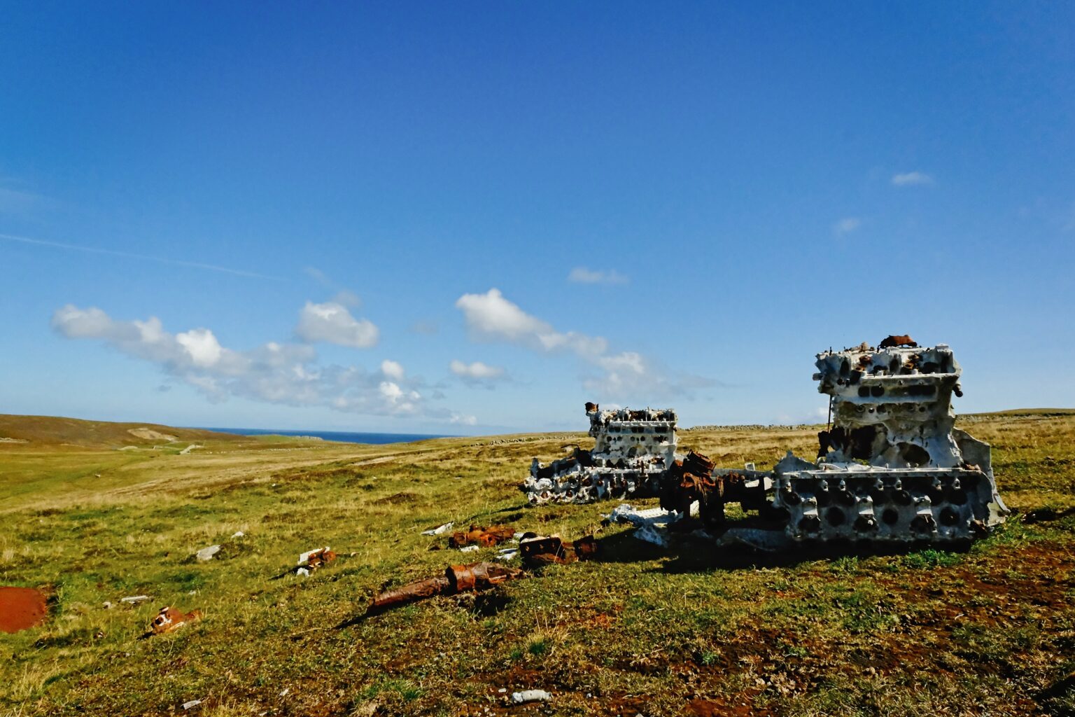 Honest documentary photography of the rusted engine blocks from a downed WWII Heinkel bomber, resting in the remote landscape of Fair Isle