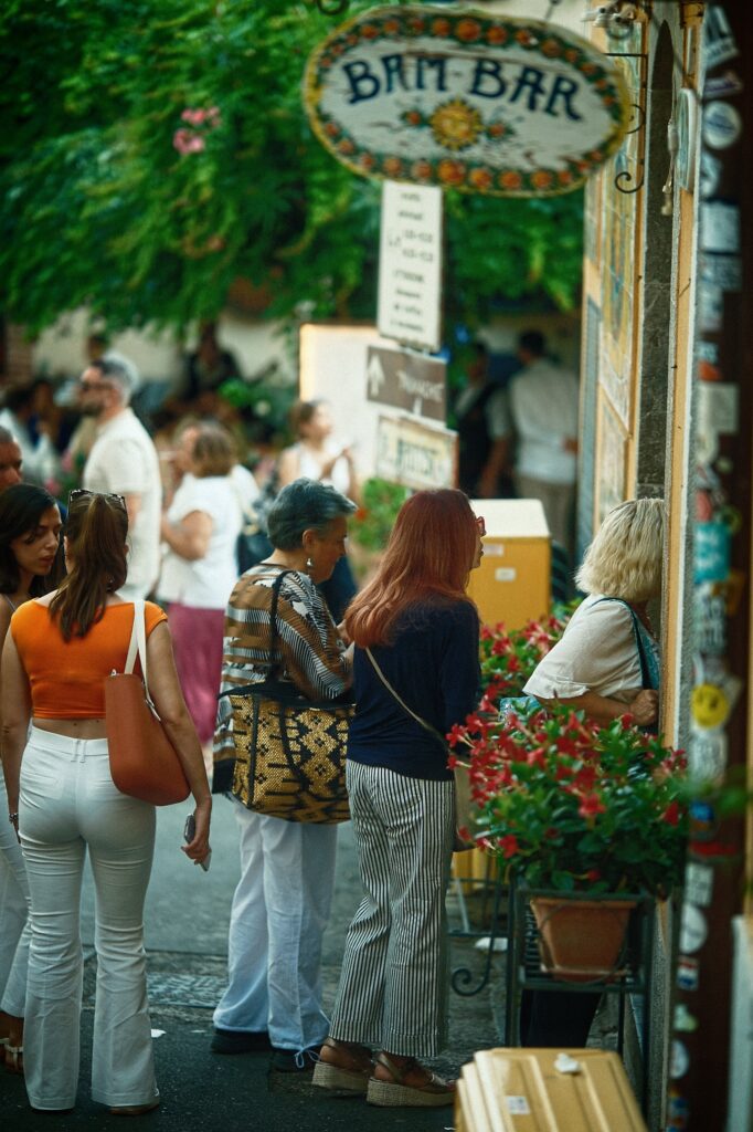 Observational street photography of a crowd queuing outside the famous Bam Bar in Taormina, capturing the buzz of local Sicilian cafe culture