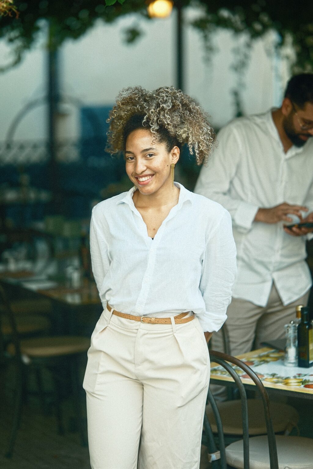 Natural editorial portrait of a woman in a white linen shirt standing in the soft Mediterranean light of Sicily