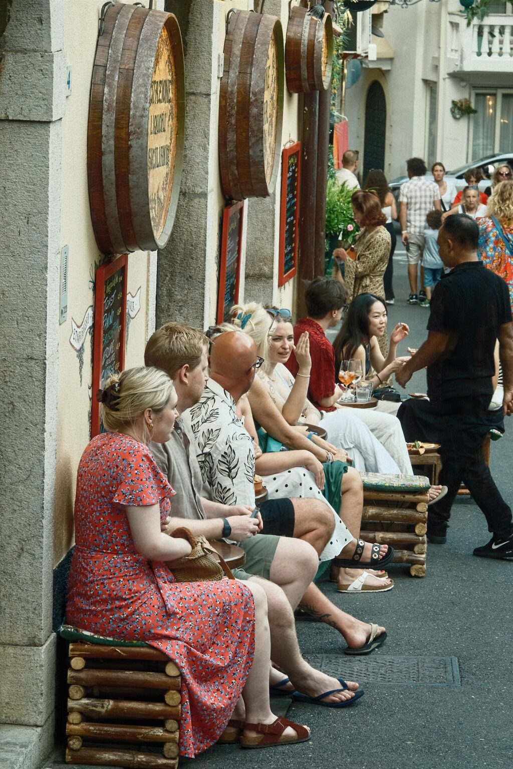 A quiet documentary scene of tourists waiting for a table at a local bar