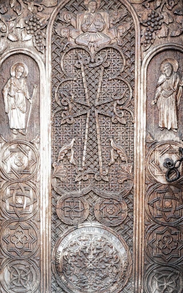 Detailed texture study of intricate medieval wooden carvings on a religious facade in Armenia