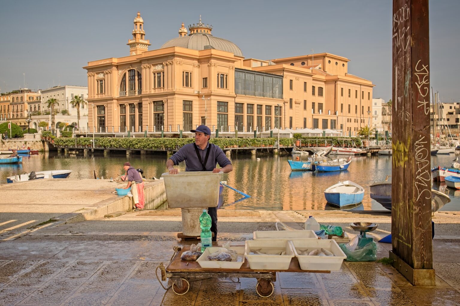 Observational documentary photography of a local fisherman working at the harbor in Bari, Italy, under warm golden light
