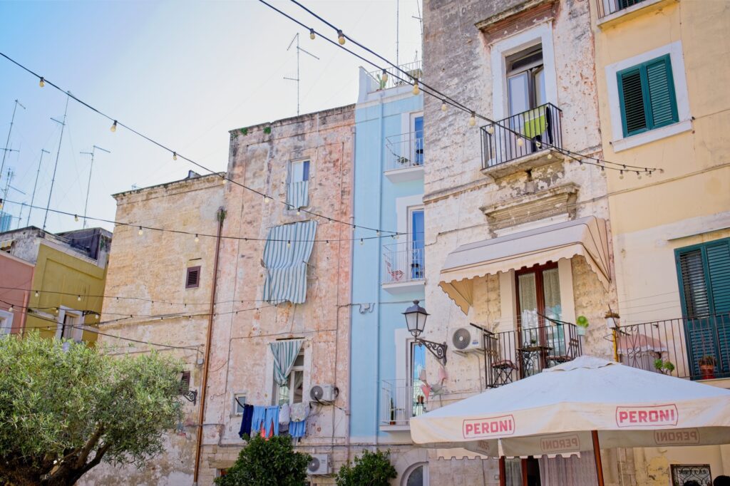 Documentary street photography of colorful residential balconies against a clear blue sky in Bari’s old town