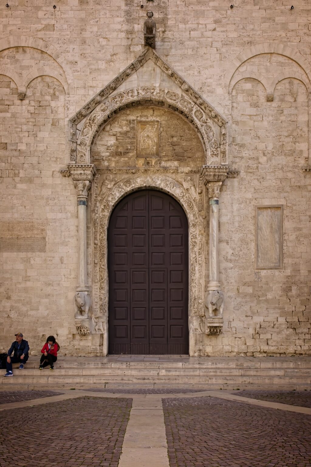 Symmetrical architectural editorial of a historic stone cathedral entrance in Bari, Italy