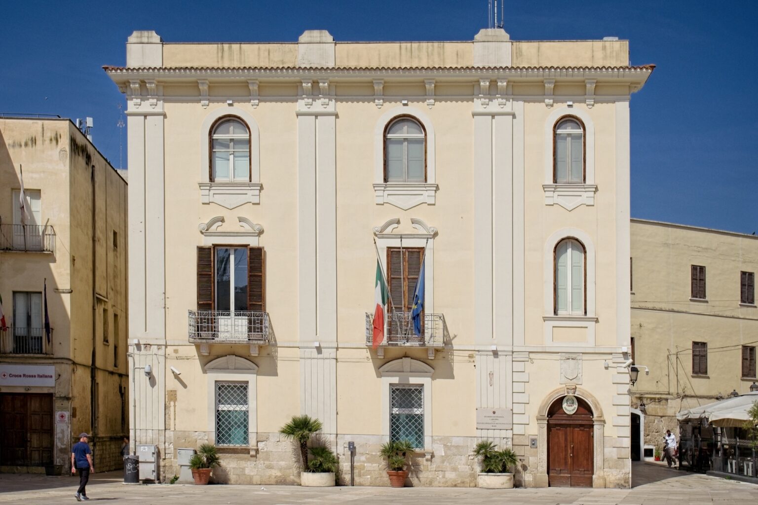Clean, high-end architectural photography of a minimalist white Italian villa under a bright midday sun.