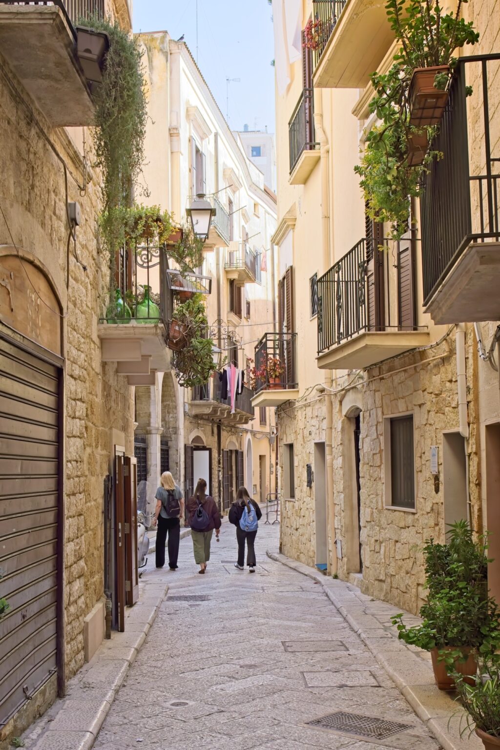 Leading lines in a narrow, golden stone alleyway in the heart of Bari’s historic district