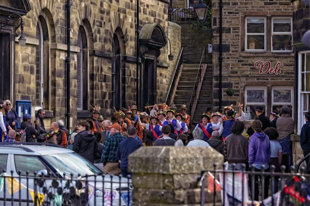 High-end travel photography of Holmfirth town center during a cultural festival