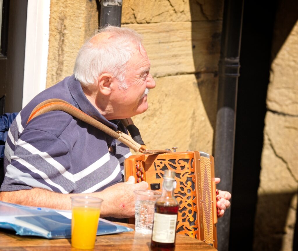 Editorial portrait of a folk musician at the Holmfirth Festival of Folk, captured in a documentary style
