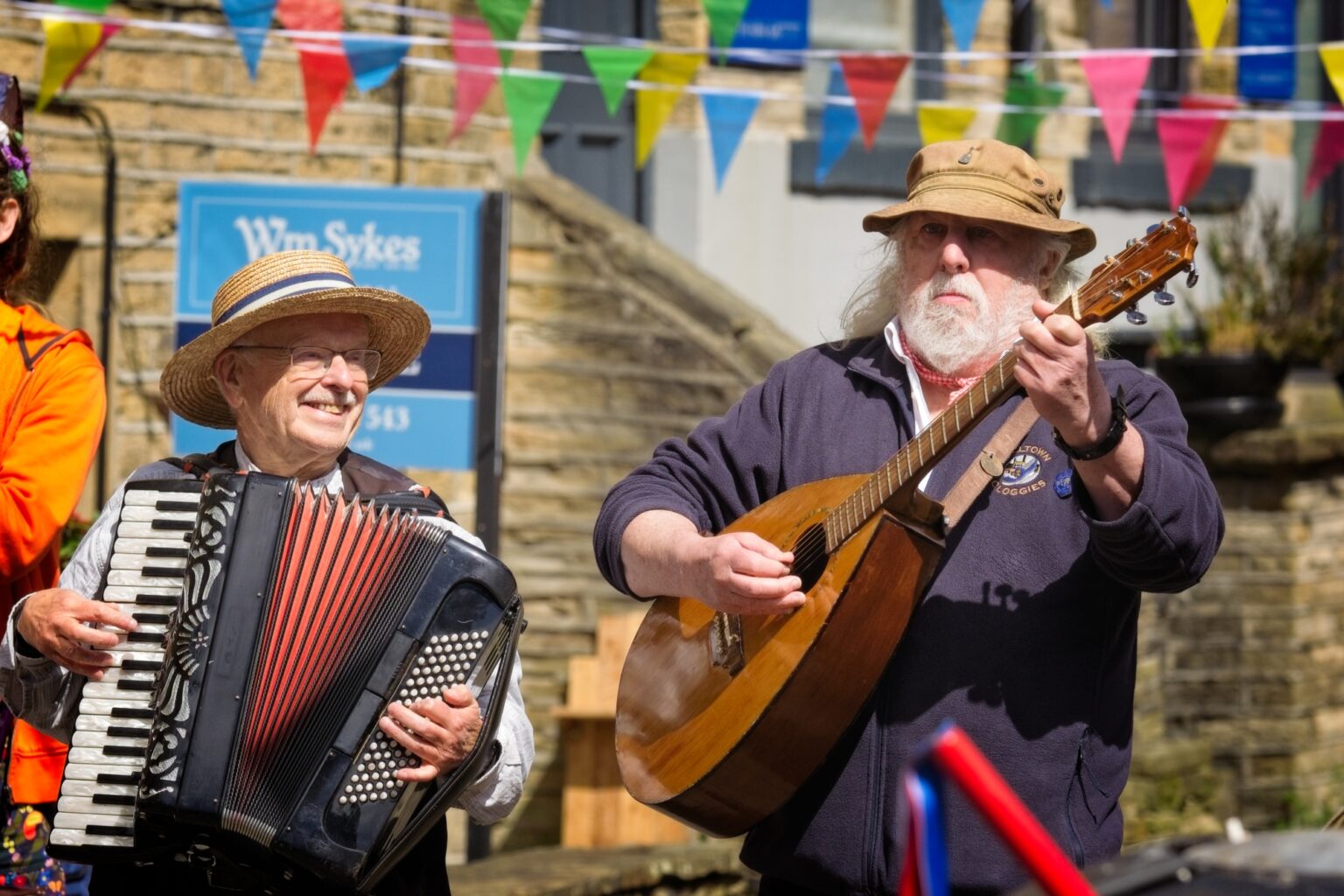 Candid editorial moment of musicians laughing in the streets of Holmfirth, Yorkshire.