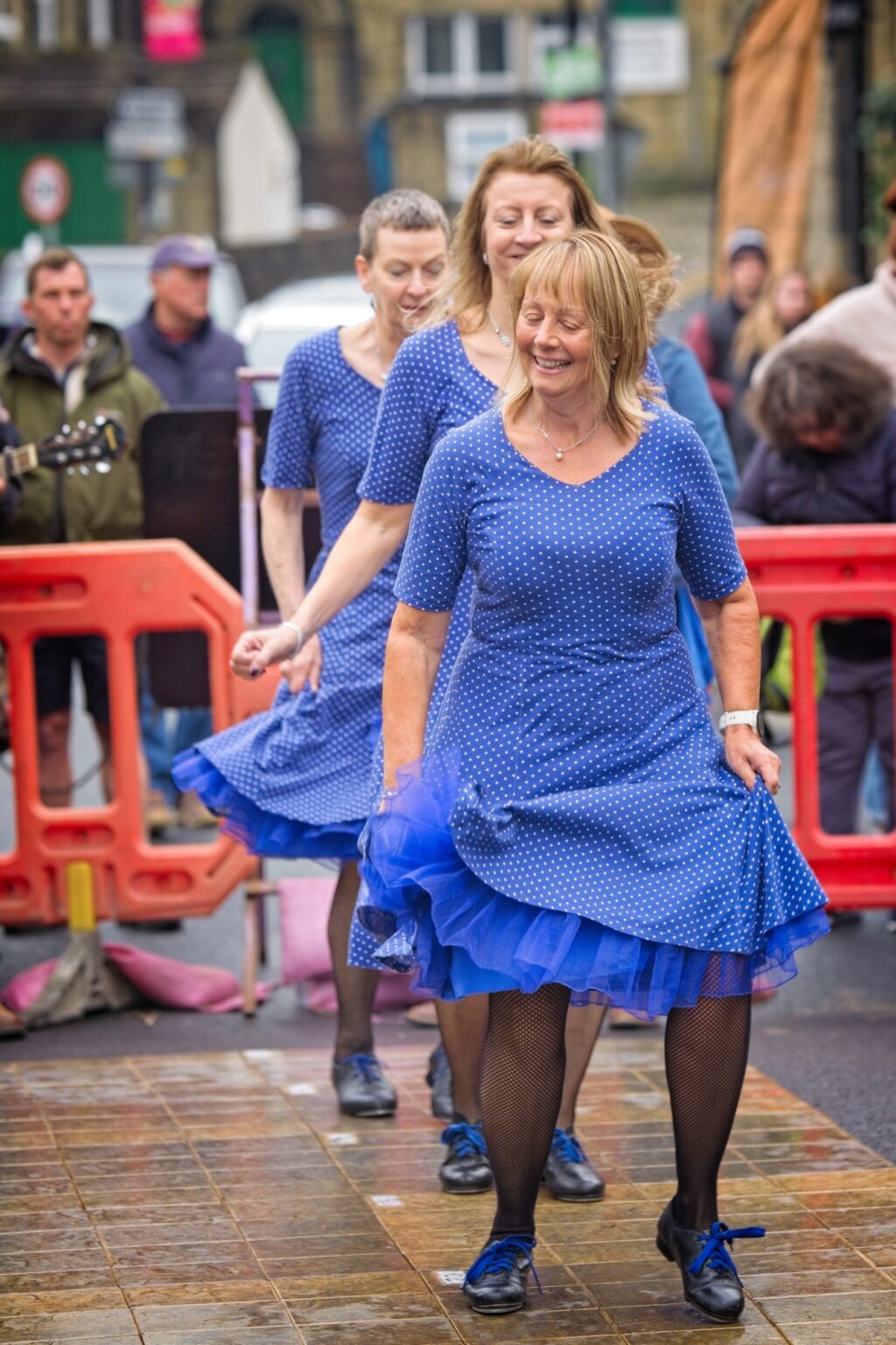 Candid editorial moment of dancers smiling in the streets of Holmfirth, Yorkshire