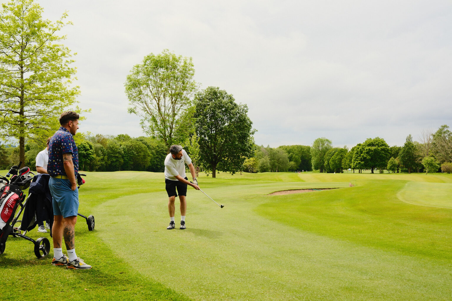 A candid shot of an attendee chipping on a golf course green during a corporate brand event.