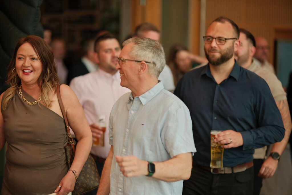 Corporate awards night attendees mingling in evening wear inside a reception lounge.